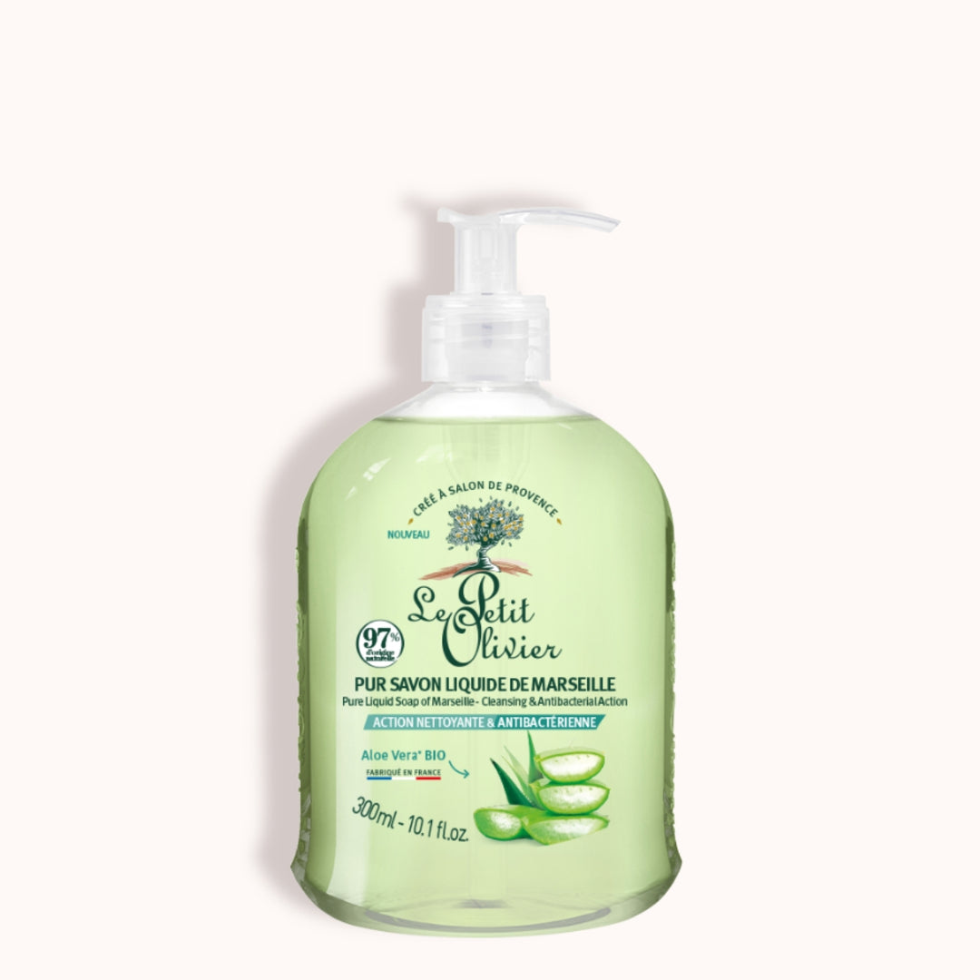 Le Petit Olivier Pur Savon Liquide de Marseille - Parfum Aloe Vera est présenté dans un flacon transparent muni d'une pompe, avec une étiquette en français, orné d'illustrations représentant du savon vert clair et de l'aloe vera, soulignant ainsi sa fabrication française.