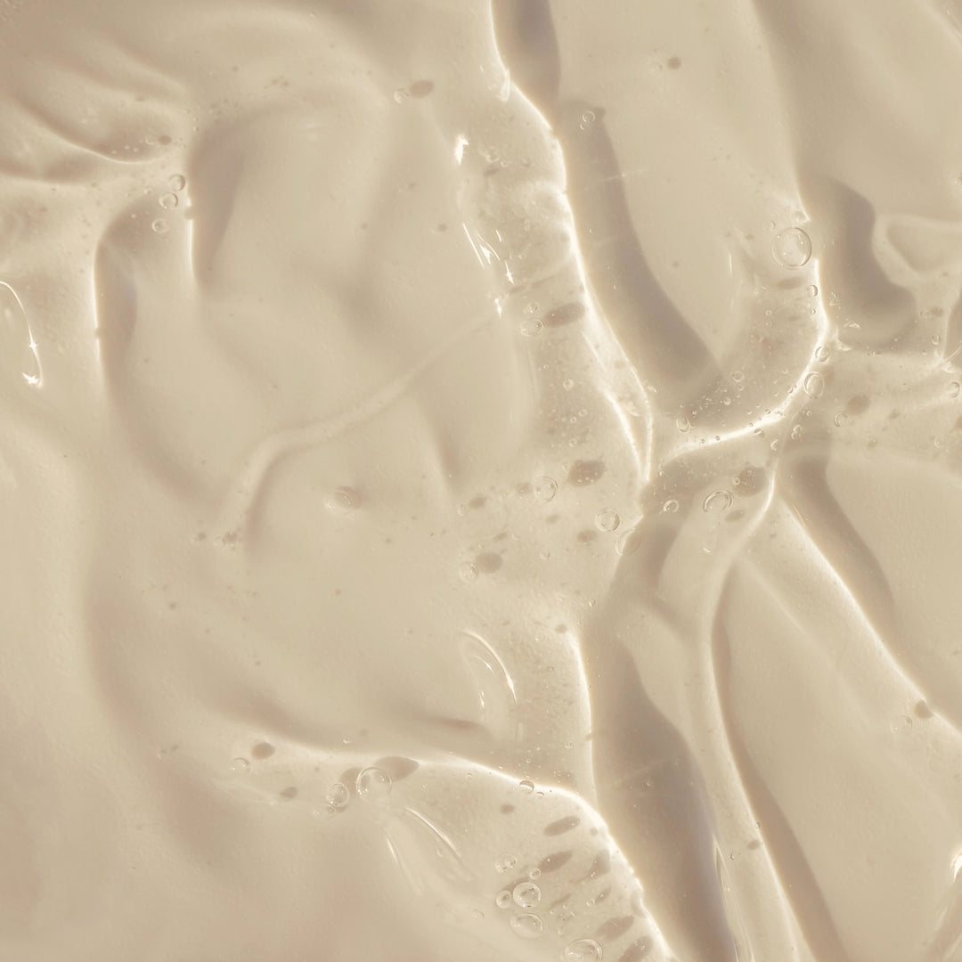 Un gros plan sur le « Pur Savon Liquide de Marseille - Parfum Aloe Vera » de Le Petit Olivier, un liquide beige onctueux et crémeux aux légères ondulations et bulles, met en valeur son action douce et sa texture abstraite, caractéristiques d'un savon traditionnel à l'aloe vera.