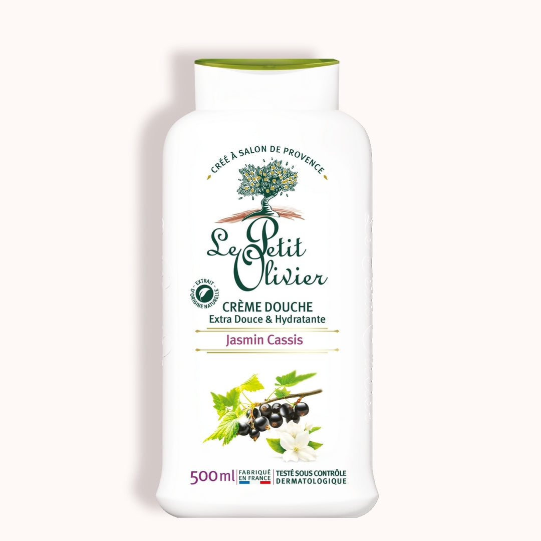 Une bouteille blanche de 500 ml de « Le Petit Olivier Crème Douche Jasmin Cassis », fabriquée en France, arbore sur son étiquette un logo représentant un arbre vert, des fleurs de jasmin et des groseilles noires, ainsi que des informations en français et des mentions dermatologiques.