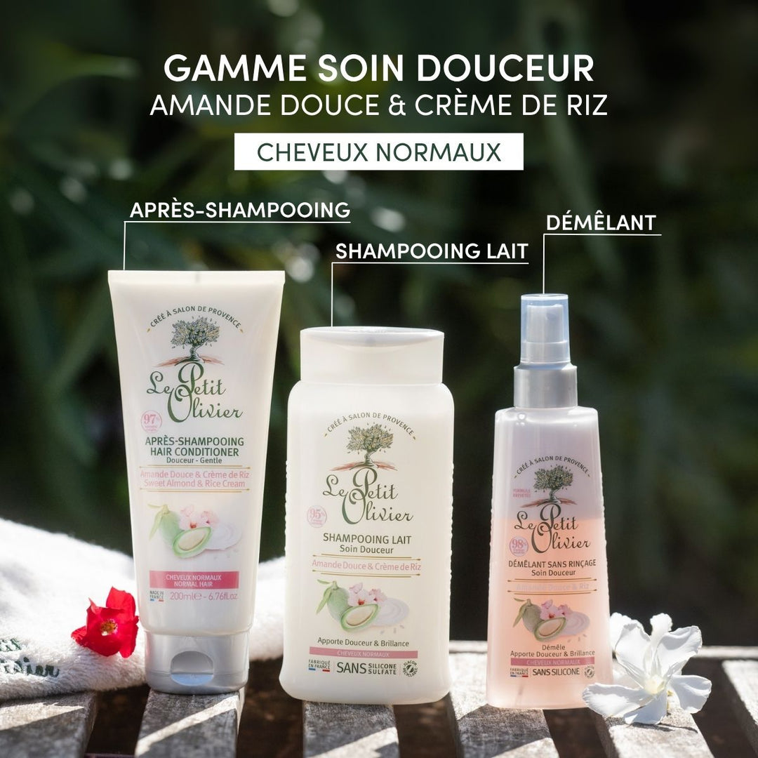 The Le Petit Olivier Shampoing Cheveux Normaux is shown outdoors on a wooden surface amid green plants. The French text highlights its formula for cheveux normaux with amande douce and rice cream.
