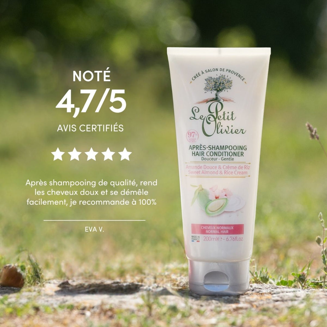 Un tube d'après-shampoing « Le Petit Olivier » pour cheveux normaux est posé à la verticale sur l'herbe, en extérieur, avec un arrière-plan naturel flou. Il affiche une note de 4,7/5 et est recommandé pour les cheveux normaux par des clients satisfaits.