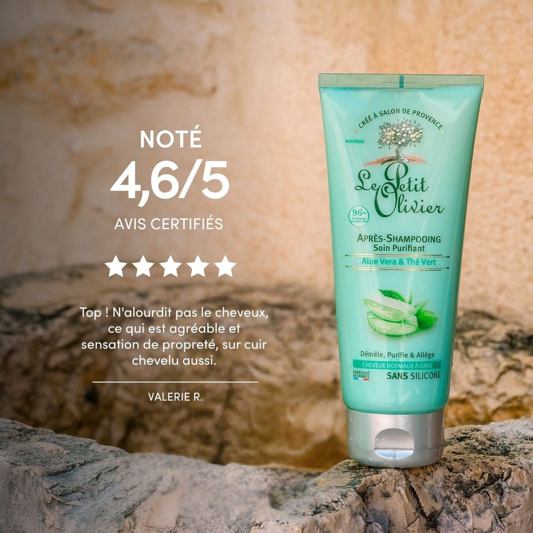 Un tube d'après-shampoing « Le Petit Olivier » pour cheveux gras est posé à la verticale sur un rocher ; on y voit une note de 4,6/5 étoiles, un avis client et les détails du produit pour les cheveux normaux à gras, le tout sur un fond naturel.