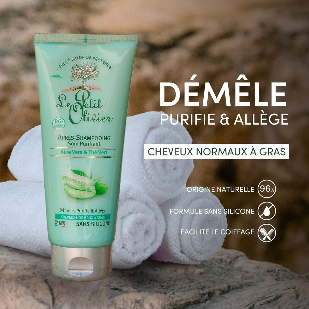 Un tube d'après-shampoing « Le Petit Olivier » pour cheveux gras est posé à la verticale sur une surface en pierre, avec des serviettes enroulées derrière lui ; le texte en français met en avant sa formule naturelle, sans silicone, à base d'aloe vera et de thé vert.