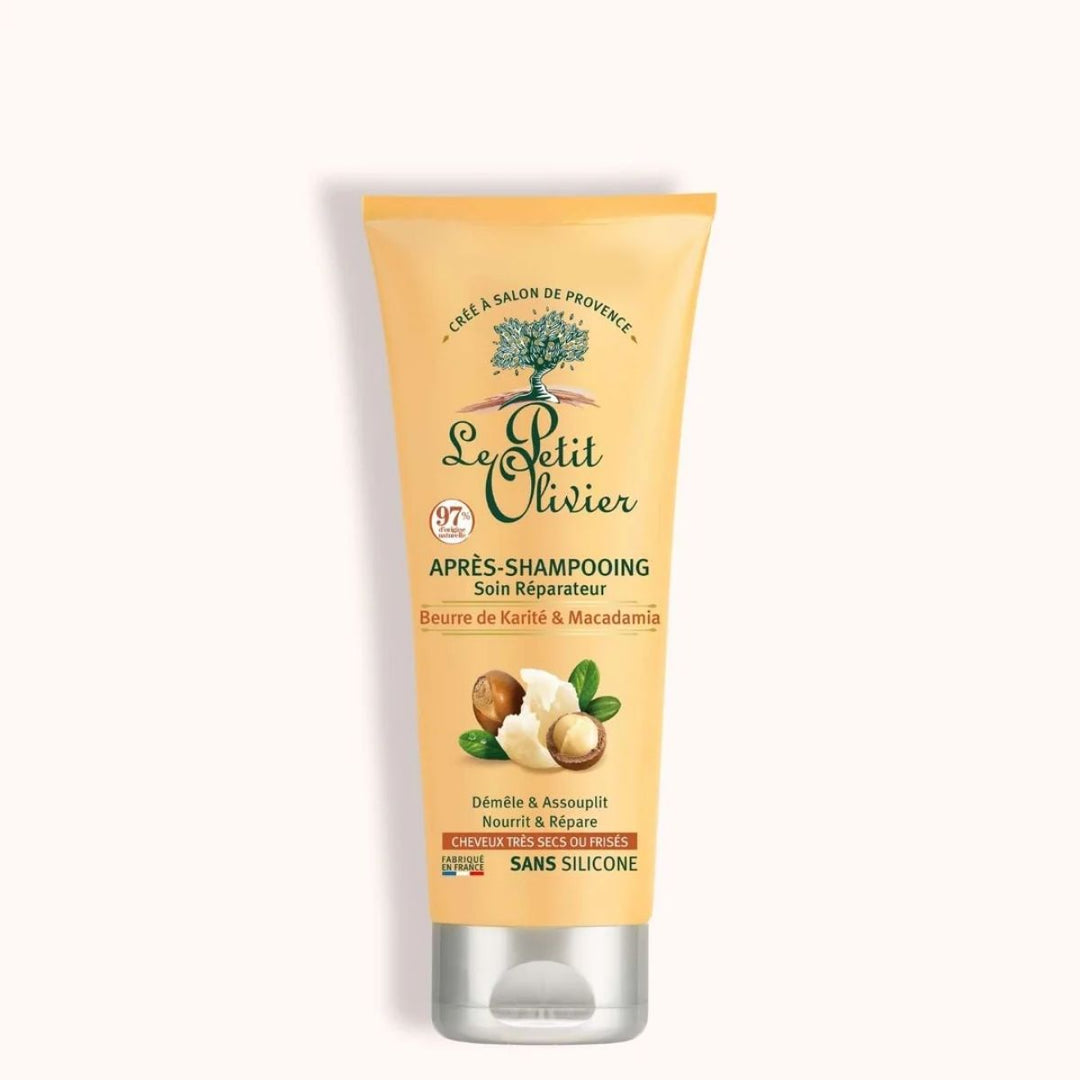 Un tube d'après-shampoing « Le Petit Olivier » pour cheveux très secs ou frisés, à base de beurre de karité et de macadamia, avec une étiquette jaune et des illustrations de noix, apporte une nutrition en profondeur aux cheveux bouclés ou très secs. Sans silicone, soin réparateur pour les cheveux.