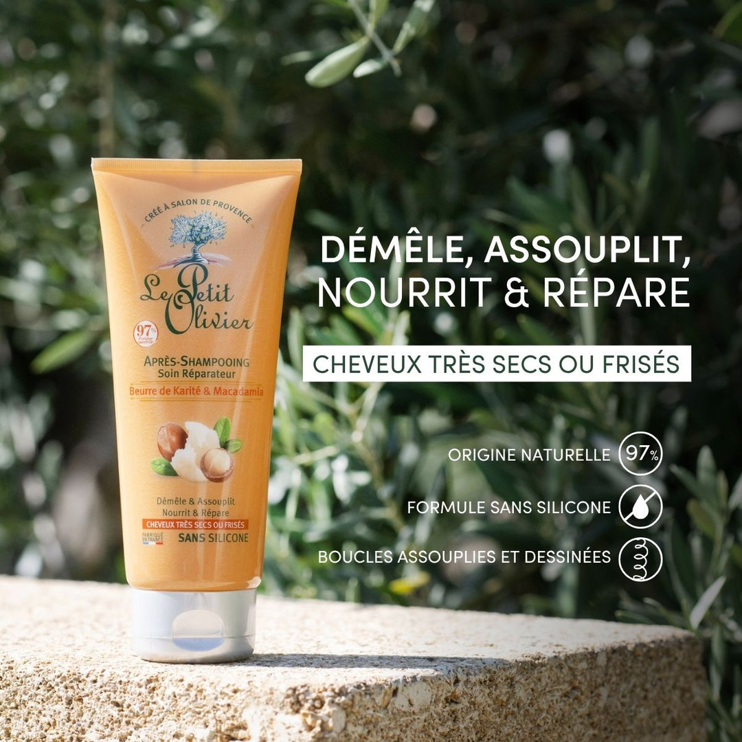 Un tube d'après-shampoing « Le Petit Olivier » pour cheveux très secs ou frisés est posé à l'extérieur, au milieu de la verdure. L'emballage indique une composition d'origine naturelle à 97 %, un soin réparateur, sans silicone, ainsi que des bienfaits démêlants, adoucissants et nourrissants pour les boucles.