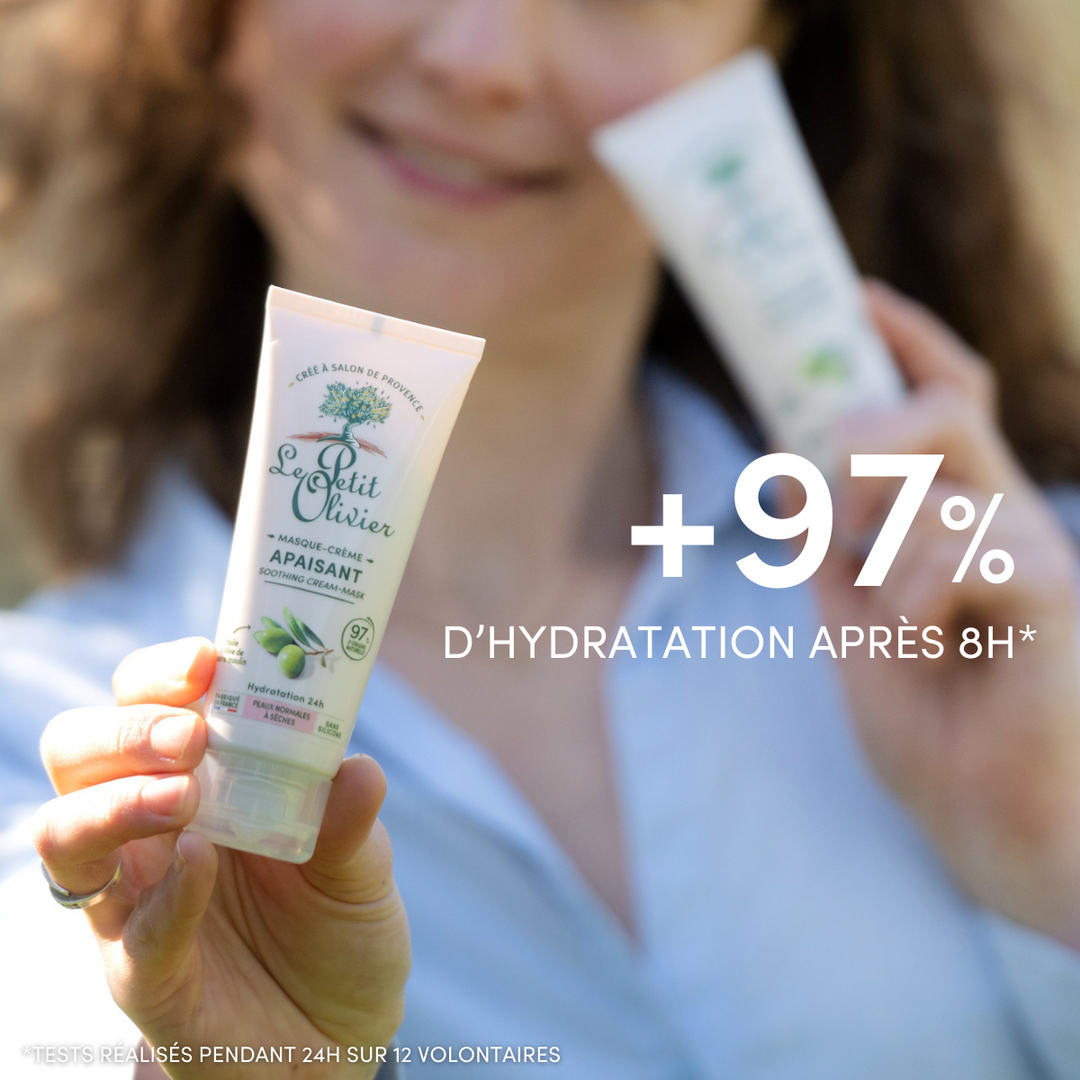 Une personne tient un tube de « Le Petit Olivier Masque Visage Hydratant 24h » orné d’un motif d’olive, idéal pour les peaux sèches. L’image met en avant une augmentation de +97 % de l’hydratation après 8 heures*, testée sur 24 heures auprès de 12 volontaires.