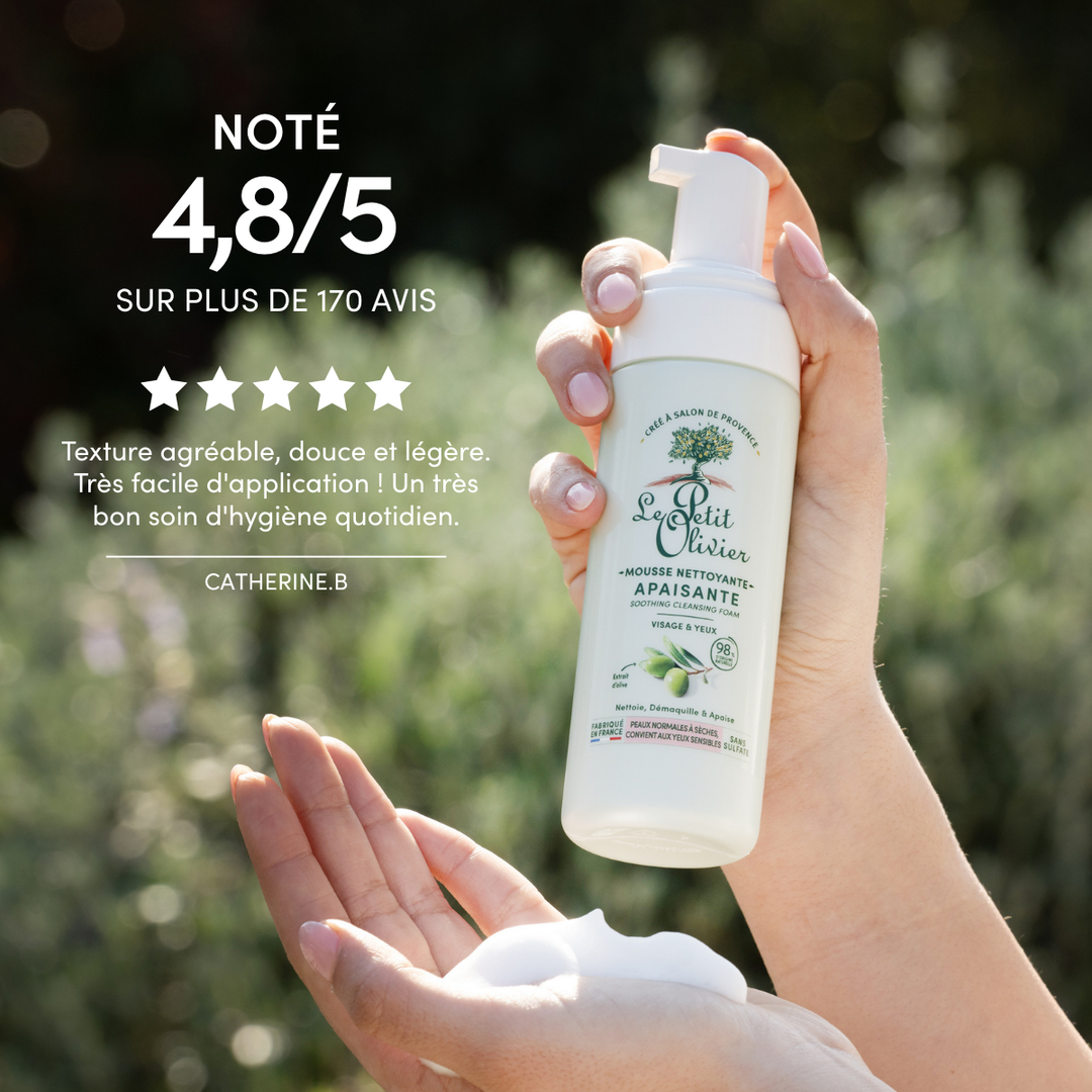 A hand dispenses Mousse Nettoyante Visage Apaisante outdoors; rated 4.8/5 stars, with a French testimonial praising its extrait d’olive as the perfect gentle cleanse for dry skin (peau sèche).