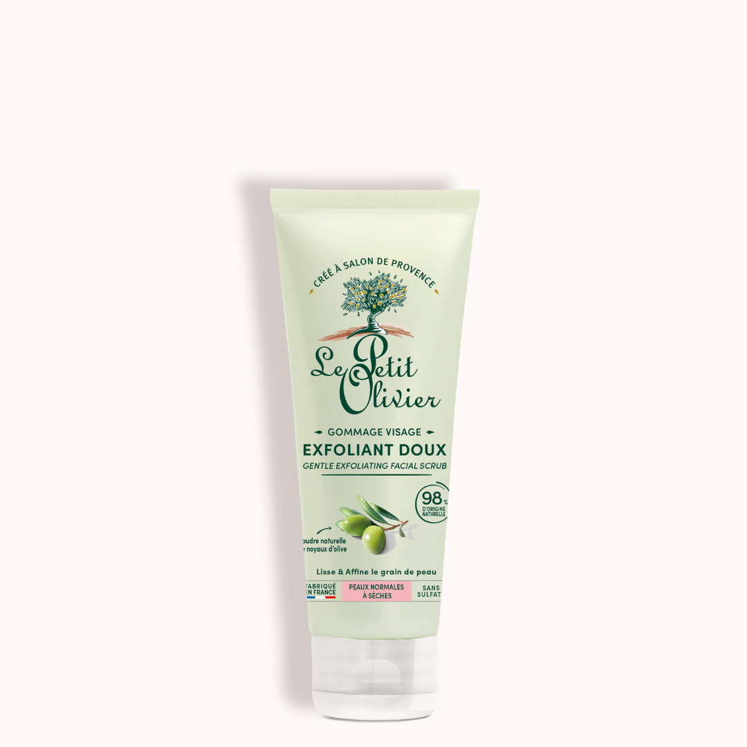 Le tube du « Gommage Visage Exfoliant Doux » de Le Petit Olivier arbore un design vert et blanc, orné d'une illustration d'olivier, et met en avant sa formule composée à 98 % d'ingrédients naturels, dont de la poudre de noyau d'olive. Ce produit convient à tous les types de peau.