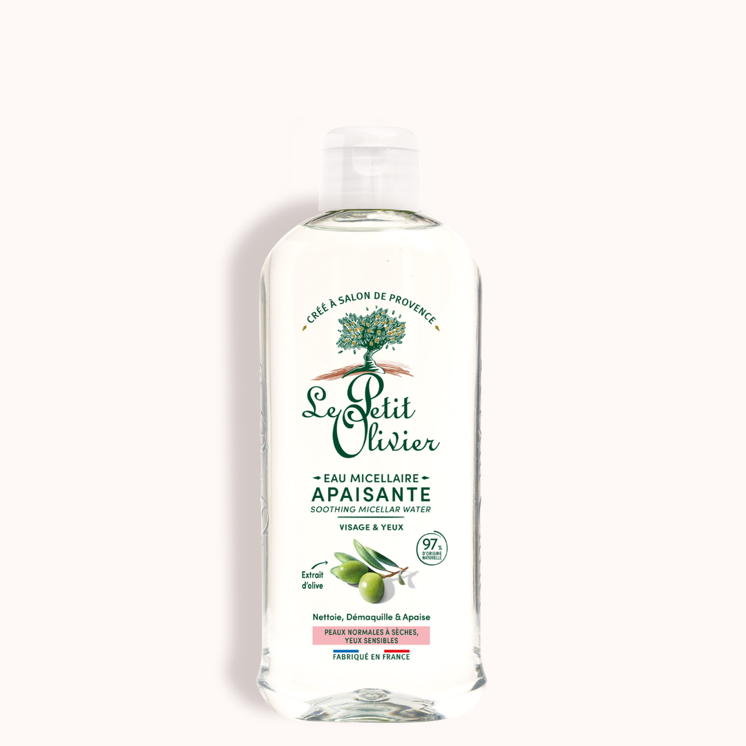Un flacon transparent de « Le Petit Olivier Eau Micellaire Démaquillante Visage & Yeux Sensibles », doté d’un bouchon blanc, d’une inscription verte et d’illustrations d’olives — idéal pour les peaux sensibles et enrichi en extrait d’olive.