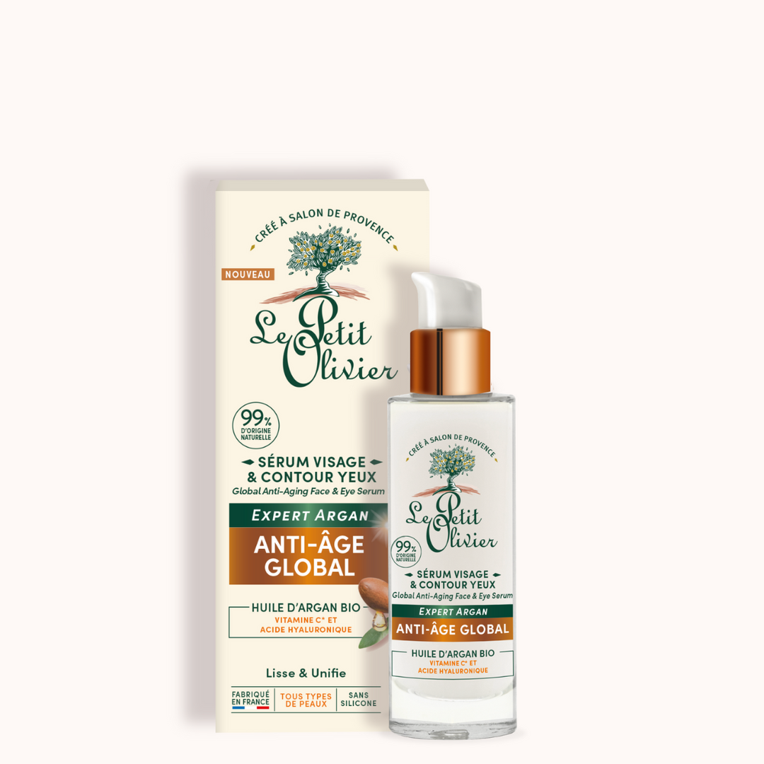 On voit ici un flacon de « Le Petit Olivier Sérum Anti-Âge Global Visage et Yeux » muni d'un doseur, posé devant son emballage, sur lequel figurent des inscriptions en vert et or mettant en avant les ingrédients naturels, l'huile d'argan bio et l'acide hyaluronique destinés aux soins du visage et du contour des yeux.