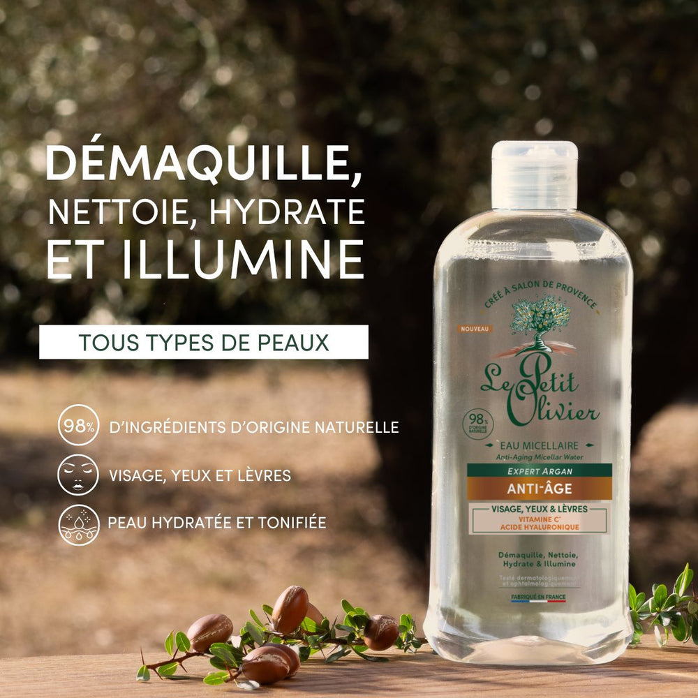 Un flacon d'Eau Micellaire Anti-Âge « Le Petit Olivier » est posé sur une surface en bois, à côté de branches d'olivier et d'olives. La marque française met en avant ses propriétés hydratantes, ses effets anti-âge et ses ingrédients naturels, ce qui la rend adaptée à tous les types de peau.