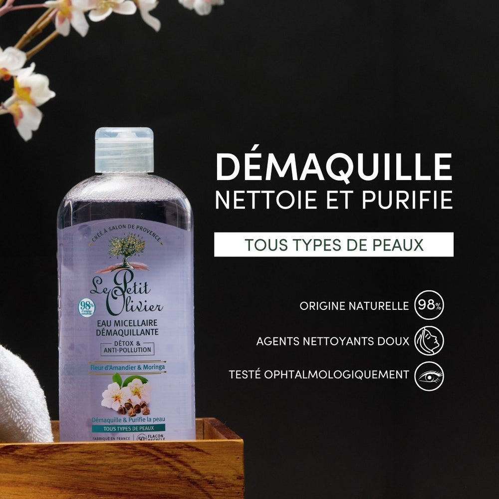 A bottle of Eau Micellaire Démaquillante Detox & Anti-Pollution rests on a wooden tray with a towel, set against a black background. Text highlights its gentle, naturally derived cleansing and anti-pollution benefits for all skin types.