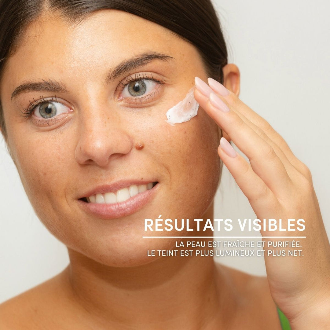Une femme à la peau claire sourit tout en appliquant le Masque Exfoliant 2 en 1 Détox & Anti-Pollution de Le Petit Olivier. Le texte en français indique : « Résultats visibles. La peau est fraîche et purifiée, pour un teint lumineux. Le teint est plus lumineux et plus net. ».