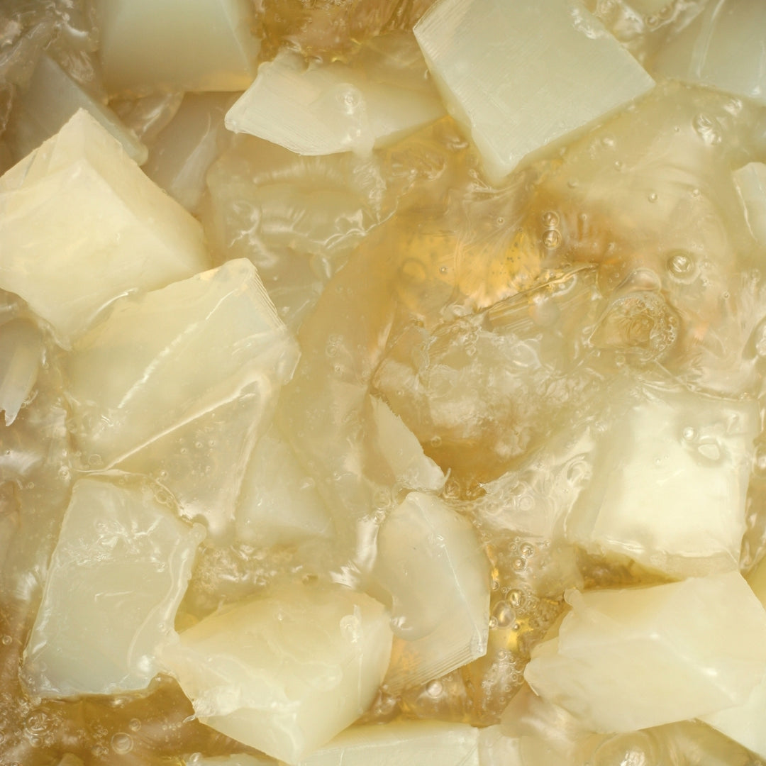 Gros plan sur le savon liquide « Recharge Pur » - Sans Parfum de Le Petit Olivier, mettant en valeur sa texture onctueuse et pure, brillante et translucide, qui rappelle des cubes gélatineux plongés dans du sirop.