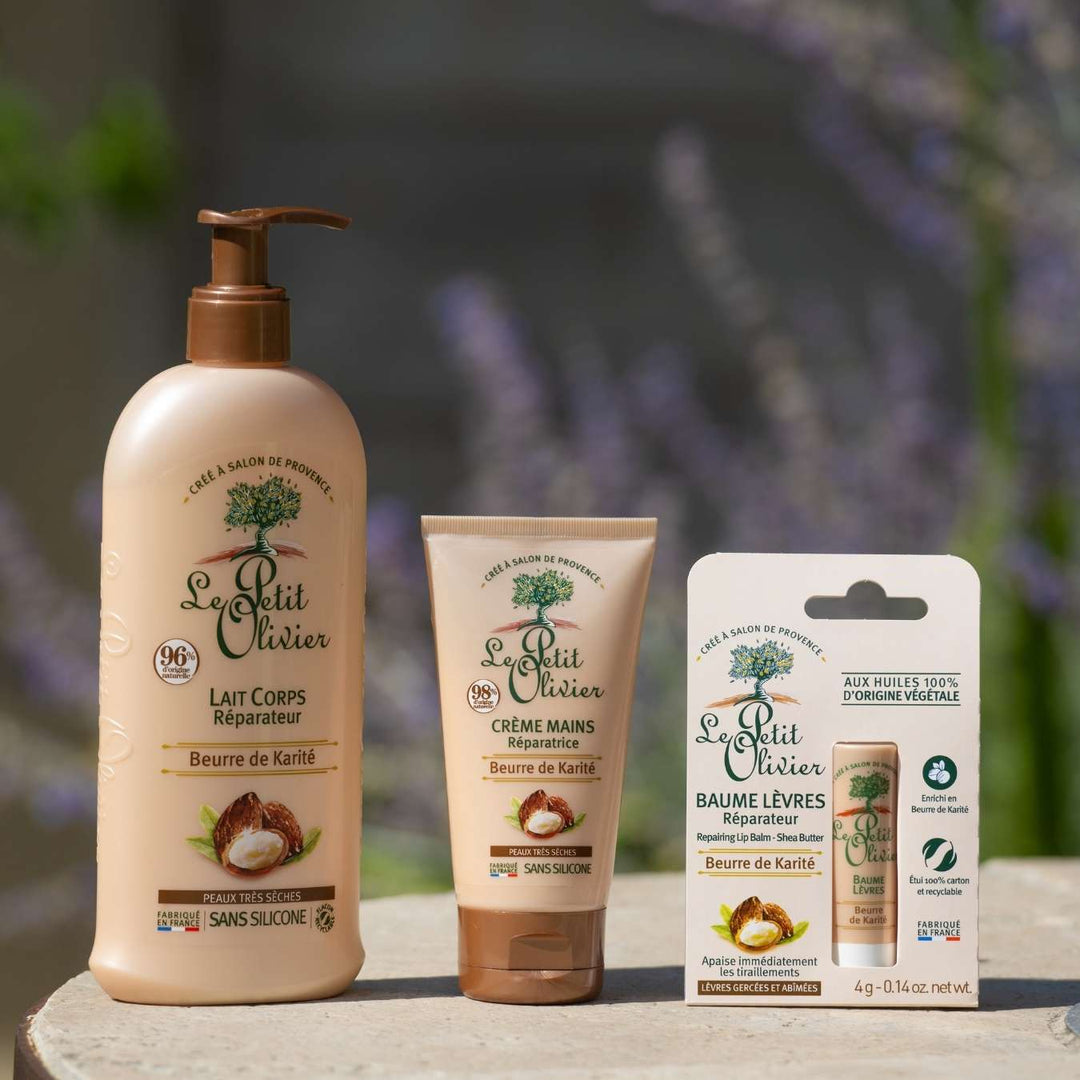Trois produits de soin « Le Petit Olivier » à base de beurre de karité sont présentés à l'extérieur : une lotion pour le corps dans un flacon pompe, une crème pour les mains en tube et un baume à lèvres en blister. Tous les emballages sont de couleur beige avec des touches de vert.