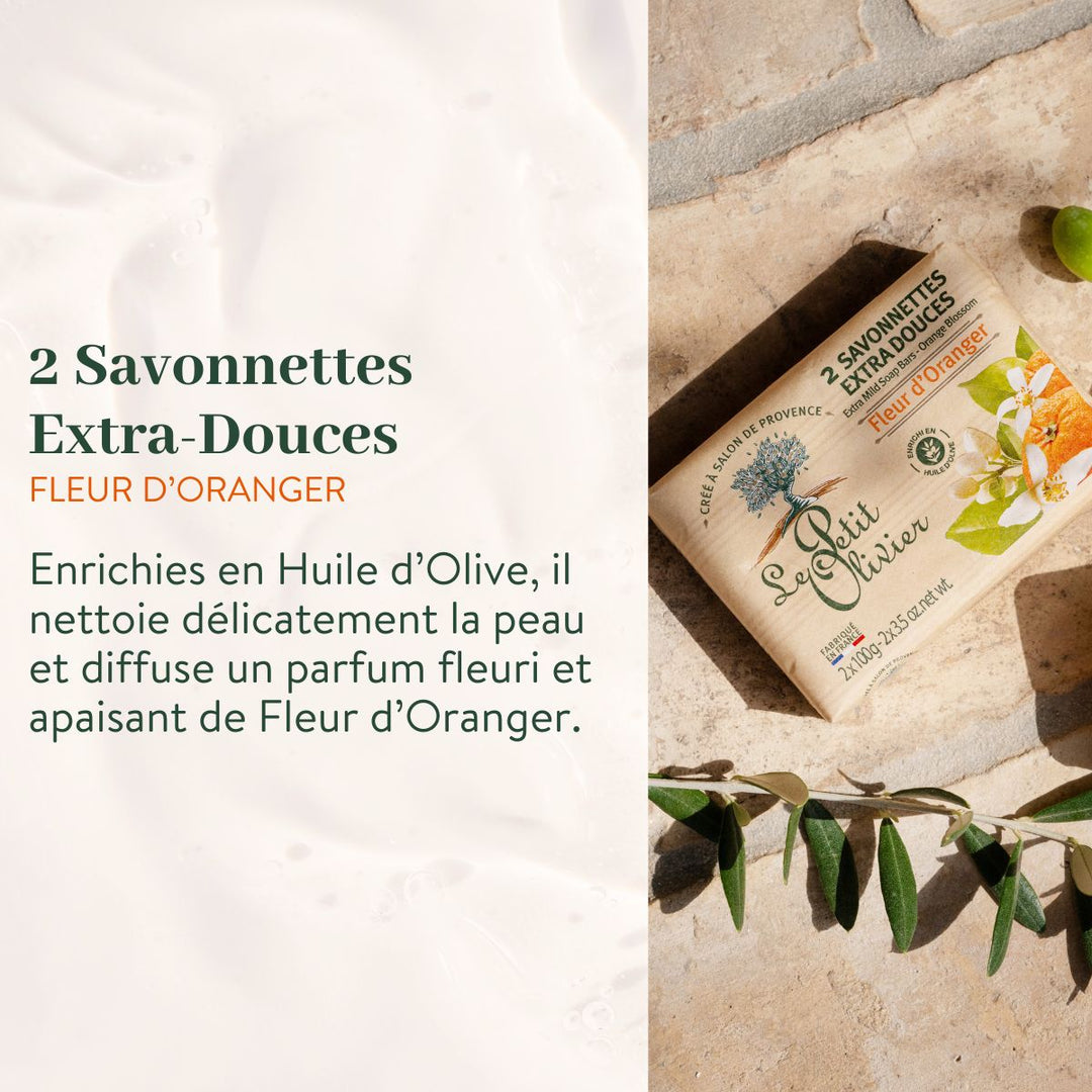 Une boîte du coffret « Découverte » de Le Petit Olivier – Savonnettes Extra Douces repose sur un socle en pierre orné de feuilles d'olivier, mettant ainsi en valeur ces savons français, enrichis en huile d'olive, qui nettoient la peau en douceur tout en diffusant un parfum floral apaisant.