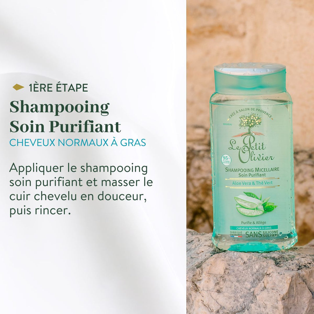 Un flacon de « Le Petit Olivier Duo Shampoing et Après-Shampoing - Cheveux Gras » repose sur une surface en pierre ; l'étiquette indique qu'il s'agit de la première étape pour les cheveux gras : masser délicatement le cuir chevelu et ne pas rincer.