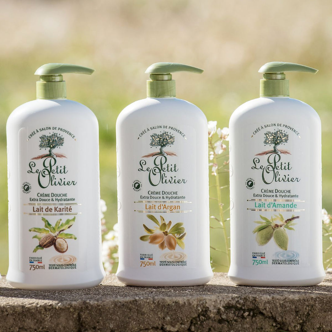 Le Pack Découverte de Le Petit Olivier – Crèmes de douche 750 ml, à base de lait de karité, de lait d'argan et de lait d'amande pour les peaux sensibles, est présenté en extérieur dans d'élégants flacons blancs dotés d'une pompe verte. Fabriqué en France.