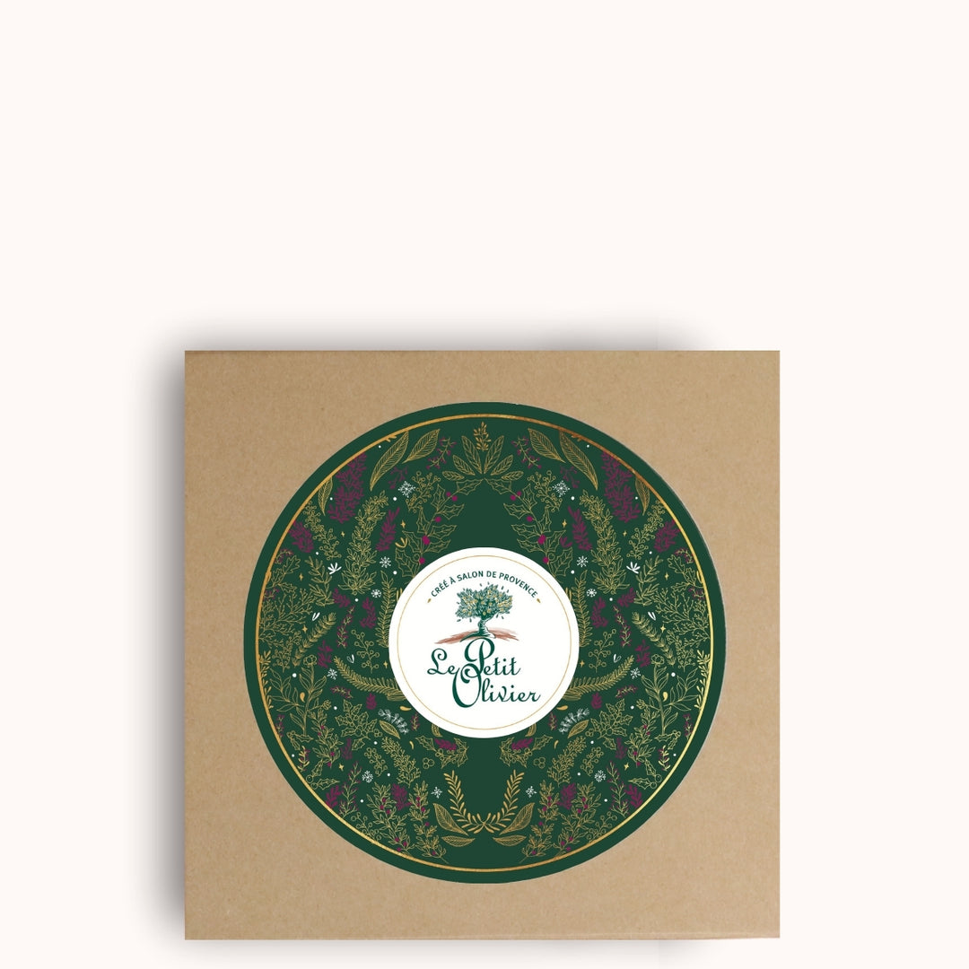 Un coffret cadeau de Noël carré de couleur marron de la marque Le Petit Olivier, orné d'un motif floral circulaire vert et du nom de la marque au centre, « fabriqué en France », sur un fond uni clair.