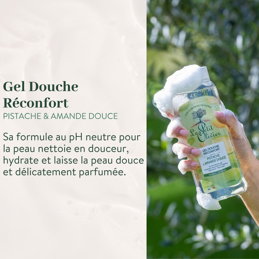 Une main tient un flacon moussant de « Le Petit Olivier Pack Découverte - Gels Douches 400 ml », sur fond vert. La formule au pH neutre hydrate la peau et laisse un doux parfum de pistache et d'amande douce.