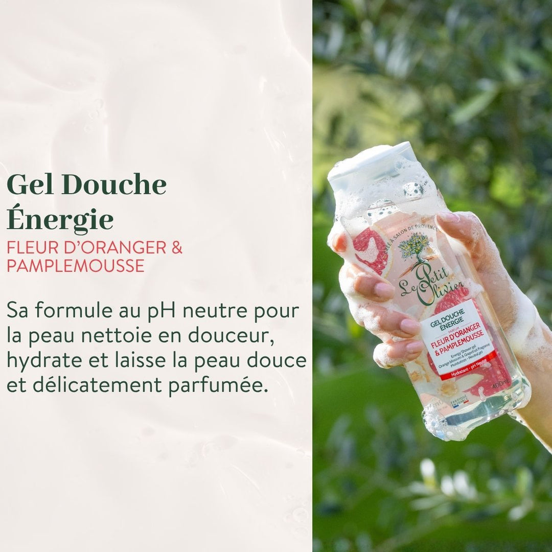Une main tient le « Duo Énergie - Gel Douche et Brume Parfumée » de Le Petit Olivier, aux notes de fleur d’oranger et de pamplemousse, au milieu d’une végétation luxuriante. Le texte met en avant son action douce et hydratante ainsi que son parfum délicat.