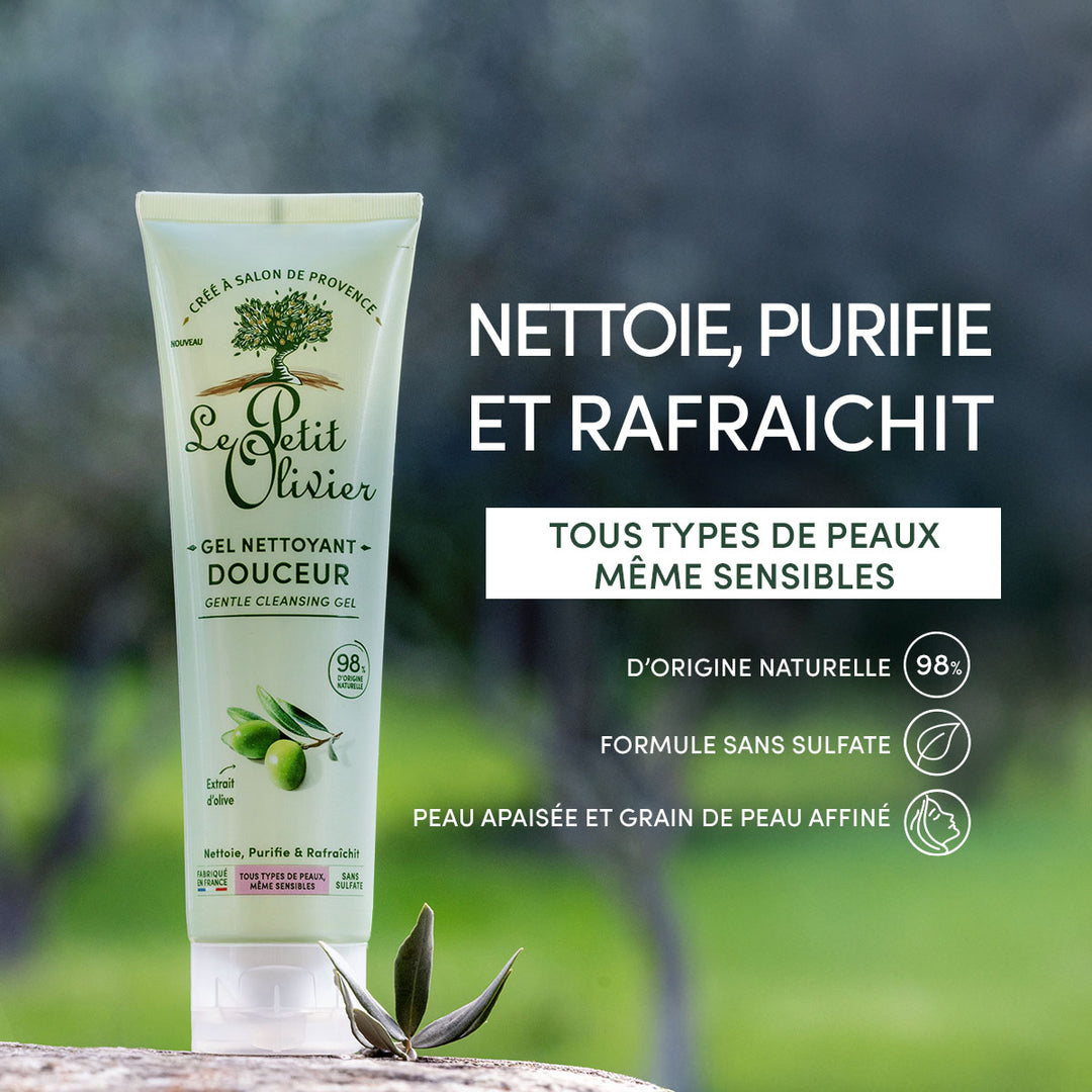 Un tube de gel nettoyant visage « Douceur » de Le Petit Olivier est posé sur une surface en bois, au milieu de la verdure. Le texte met en avant ses origines naturelles, sa formule sans sulfate, son adaptation aux peaux sensibles, ainsi que ses bienfaits purifiants et rafraîchissants.